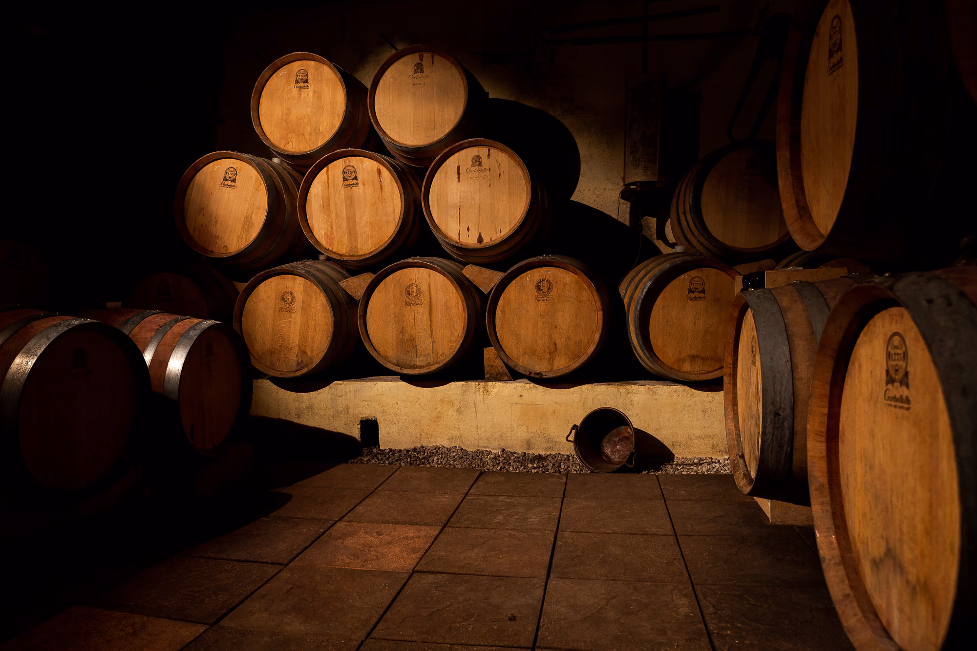 Barrique allineate nella bottaia in penombra della Cantina Col Dovigo